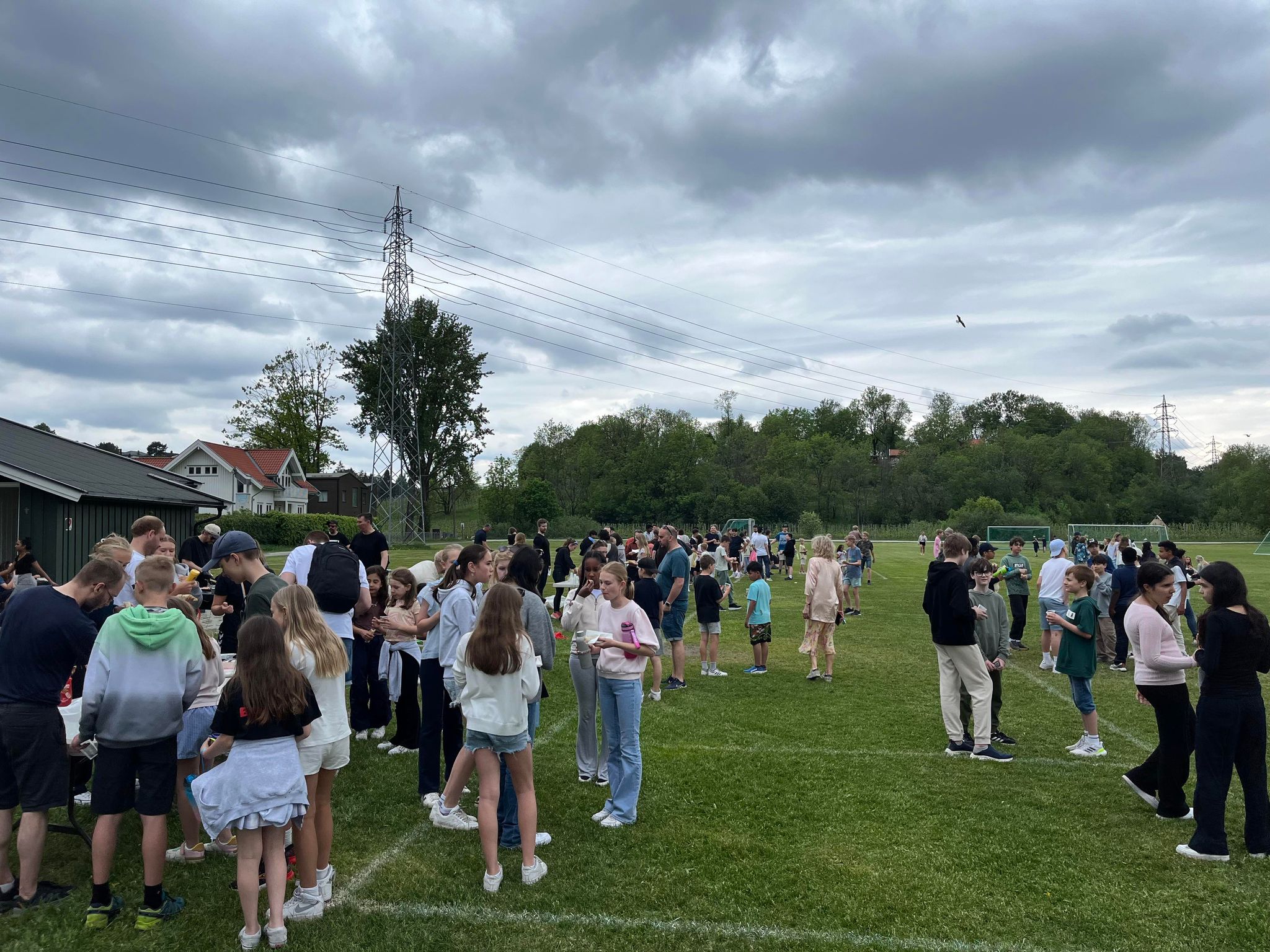 En gruppe mennesker som står på gress