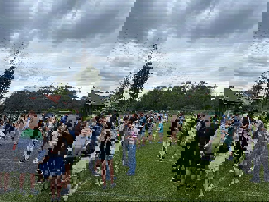 En gruppe mennesker som står på gress