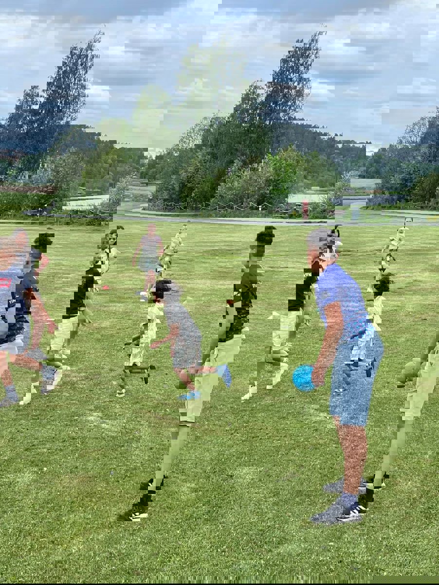 en gruppe barn som leker med en ball på et jorde