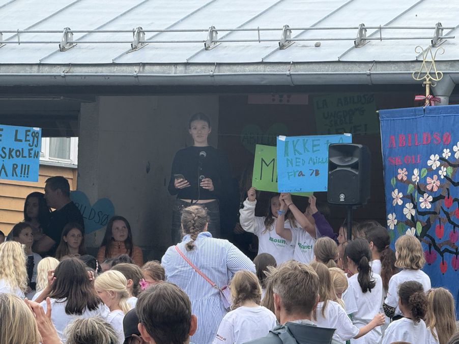 en person på en scene med en mikrofon foran en folkemengde