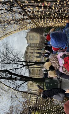 en gruppe mennesker som står på fortauet med et tre i bakgrunnen