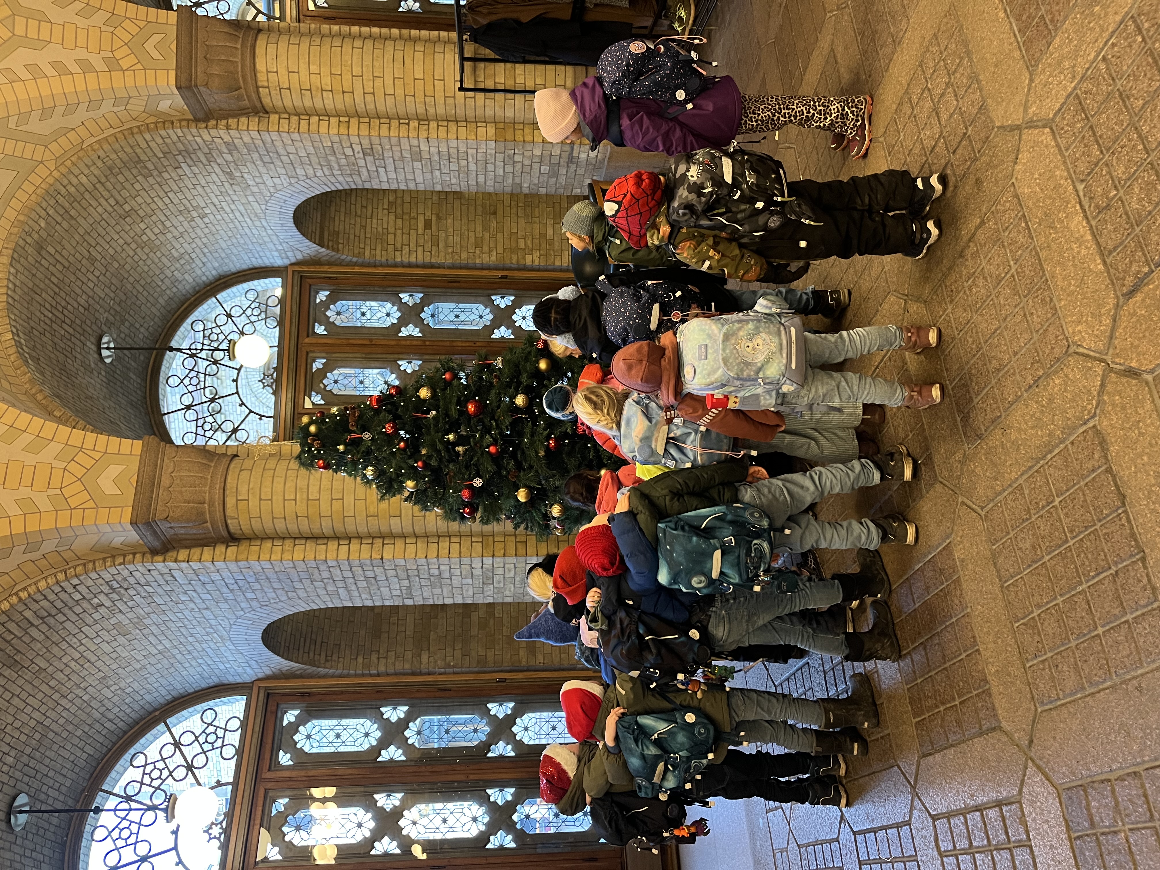 en gruppe mennesker i klær i en bygning