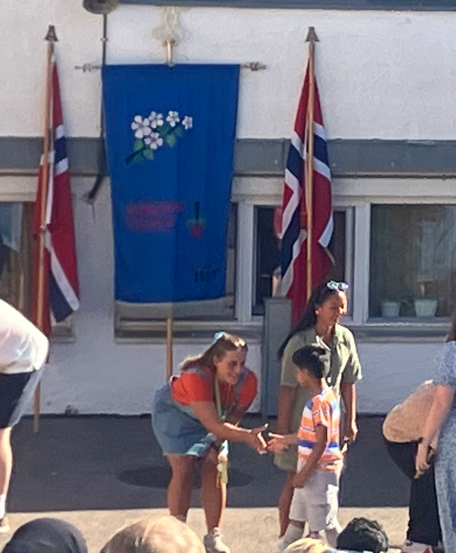en gruppe mennesker som står utenfor en bygning med flagg
